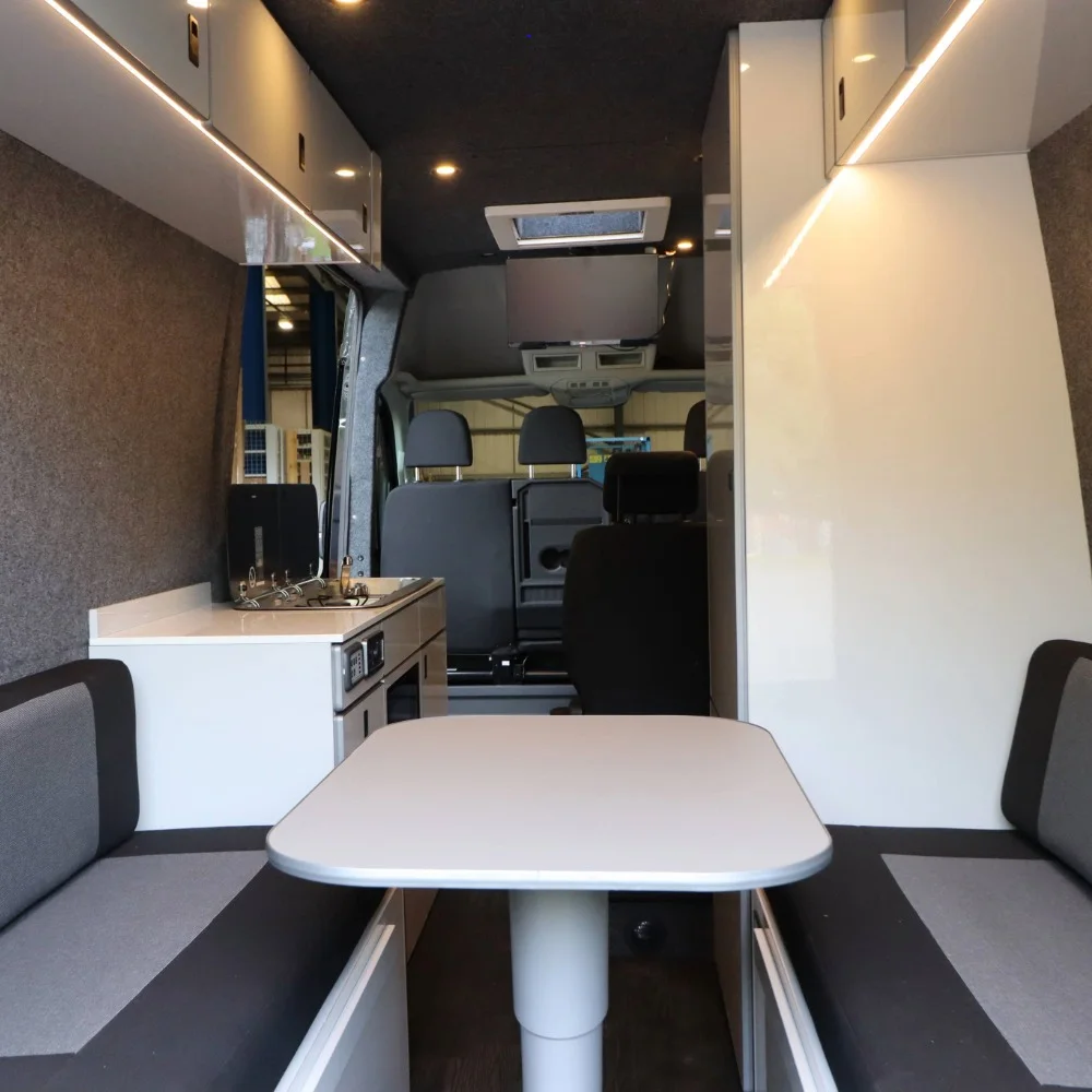 A small white table with two seats inside a camper.
