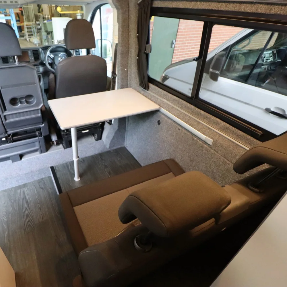 A small white table behind the driver's seat of a camper van.