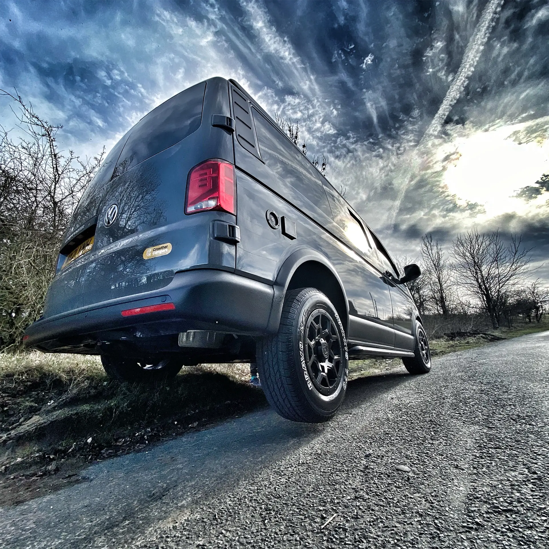 Black camper by the side of the muddy road