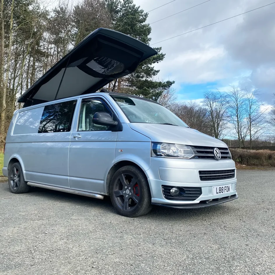Parked up silver camper with the roof extended