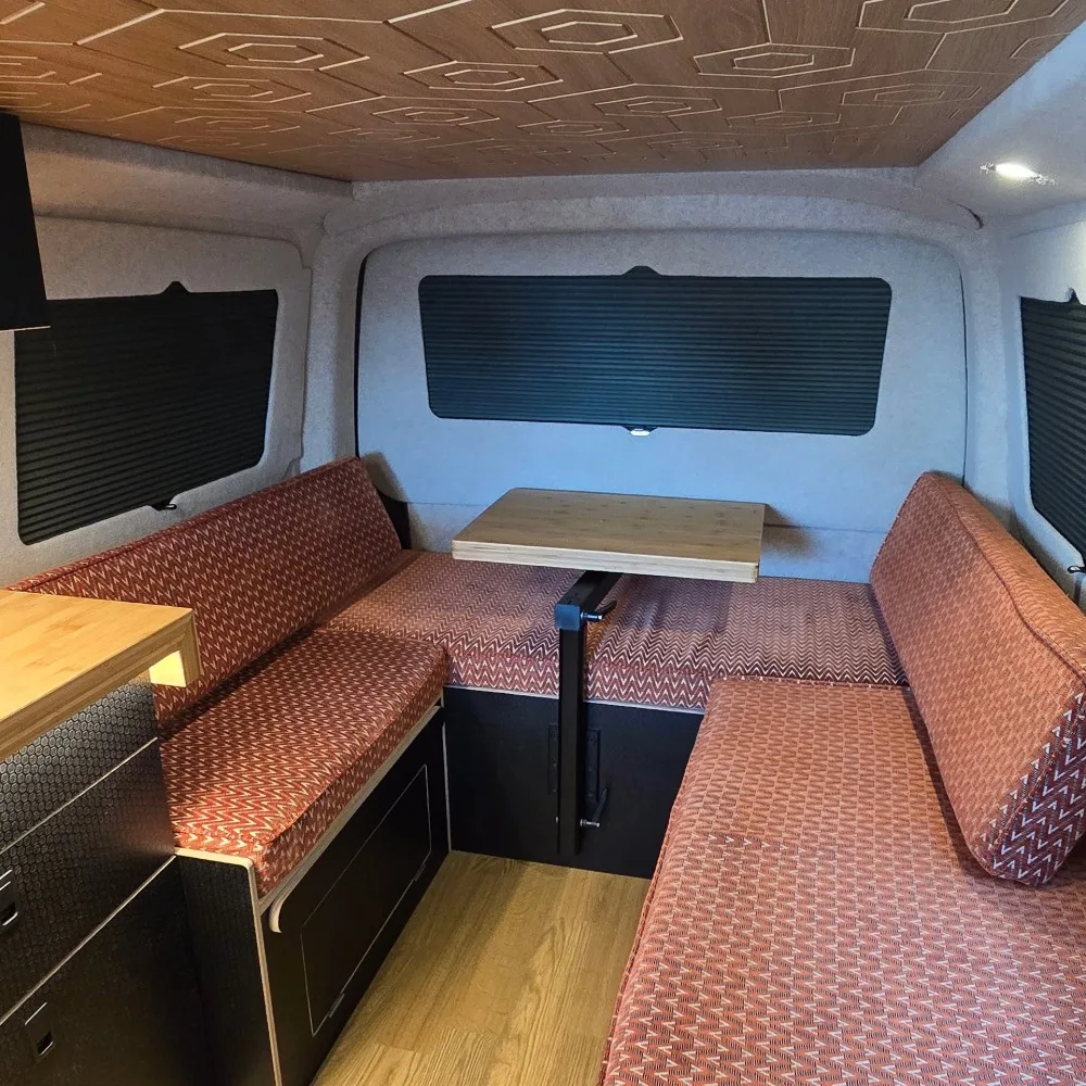 A VW Transporter T^ interior with wood finishes and orange upholstery.