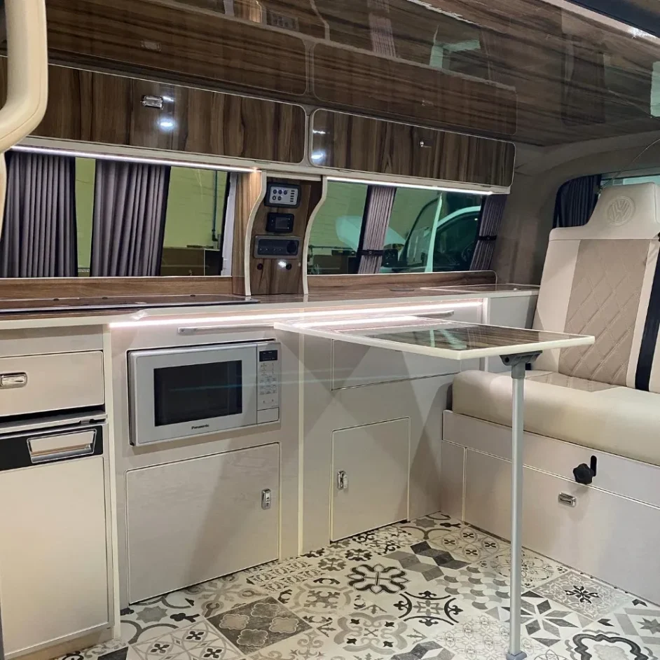 A camper van kitchen with an integrated microwave.