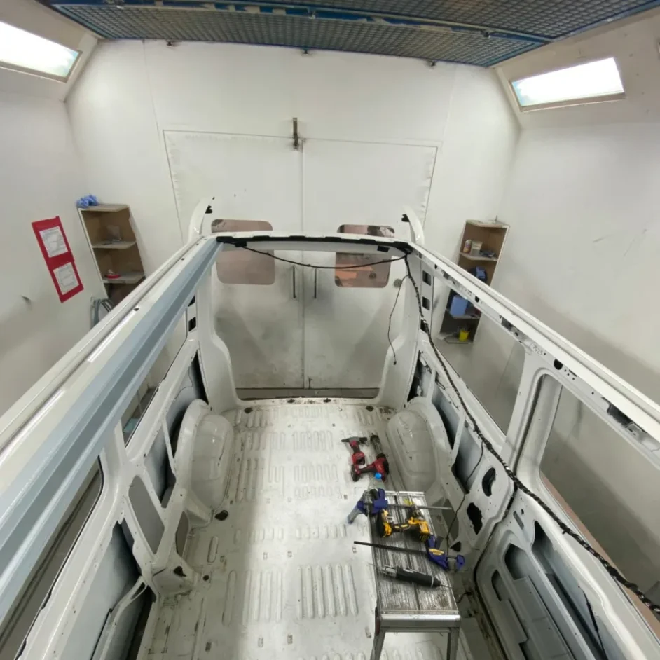 The metal frame of a camper van being prepared for conversion.