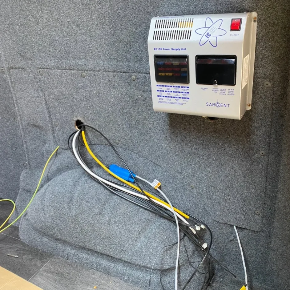 A bundle of wires running through a camper van interior.
