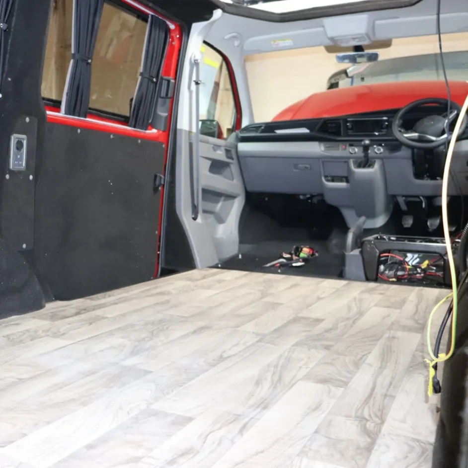 A camper van interior with black fabric insulation panels.